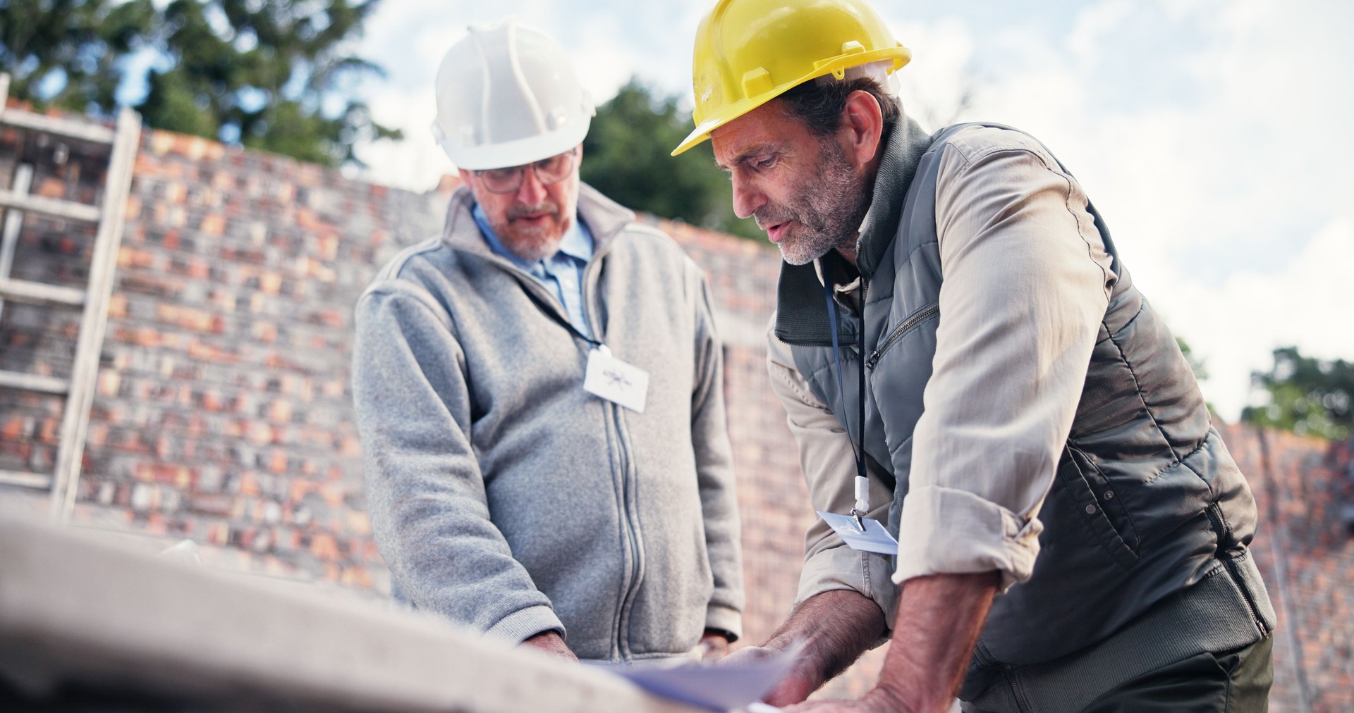 Contractor, meeting and people on construction site for floor plan, inspection or collaboration at table. Engineer, discussion and men with blueprint, brainstorming or architect design in morning